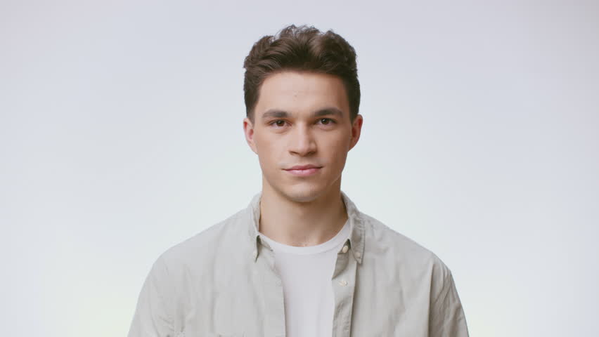 Young handsome man posing in a neutral background with a friendly smile