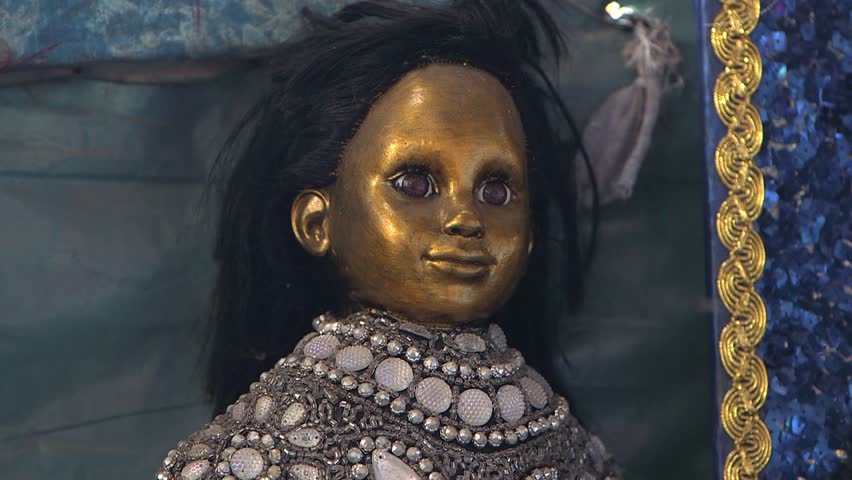Port-au-Prince, Haiti - February 25 2019 - Doll painted with gold paint and dressed in rich finery, for a voodoo ceremony