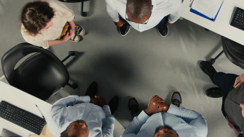 Top down view zoom out of company employees uniting hands and cheering their group success, project planning and data analytics. Colleagues focus on resource allocation to achieve progress. Camera A. - Powered by Shutterstock - Get 15% off with code: PIKWIZARD15