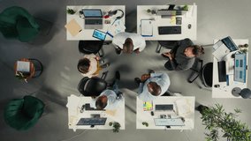 Top down view of business people celebrating teamwork with files and diagrams in collaborative office. Work team aligns strategy and management with insights for improved performance. Camera A. - Powered by Shutterstock - Get 15% off with code: PIKWIZARD15