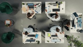 Top down view of diverse coworkers analyzing business data and metrics during report sharing session in boardroom. Professional work team discuss forecasting and management insights. Camera A. - Powered by Shutterstock - Get 15% off with code: PIKWIZARD15