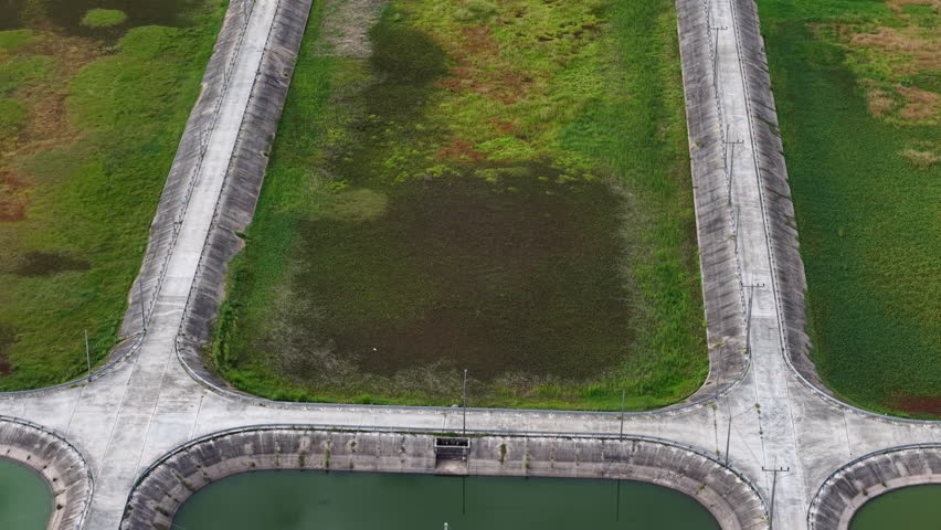 High-angle 4K drone footage shows a systematic arrangement of large, rectangular wastewater lagoons, crucial for industrial water purification and environmental conservation.