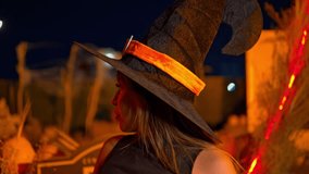 Latina woman in a witch costume with red lipstick posing and smiling at night for halloween - Powered by Shutterstock - Get 15% off with code: PIKWIZARD15