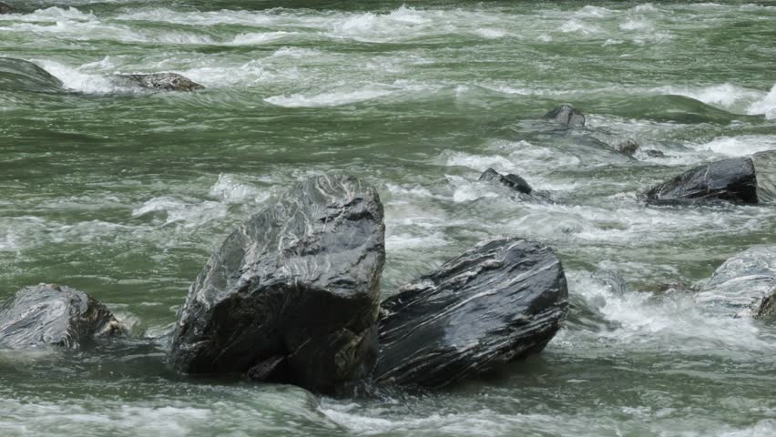 Mountain River Water Flowing Over Stone Rapids In Haast, New Zealand
