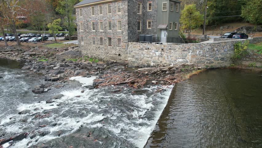 ascending drone shot of historic delaware mill on gray autumn day on brandywine river