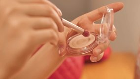 Young woman applying makeup surrounded by cosmetics. Beauty, skincare, and selfcare concept showing daily makeup routine with brushes, lipstick, and foundation in natural light - Powered by Shutterstock - Get 15% off with code: PIKWIZARD15