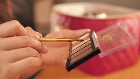 Young woman applying makeup surrounded by cosmetics. Beauty, skincare, and selfcare concept showing daily makeup routine with brushes, lipstick, and foundation in natural light - Powered by Shutterstock - Get 15% off with code: PIKWIZARD15
