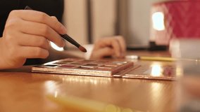 Young woman applying makeup surrounded by cosmetics. Beauty, skincare, and selfcare concept showing daily makeup routine with brushes, lipstick, and foundation in natural light - Powered by Shutterstock - Get 15% off with code: PIKWIZARD15