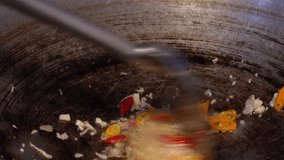 garlic, shallots, and chili peppers being sautéed (tumis) in a hot, rustic cast iron wok or pan. Focus on the rapid stirring motion blur and bubbling oil. Ideal for cooking tutorials, Asian cuisine - Powered by Shutterstock - Get 15% off with code: PIKWIZARD15