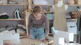 Female fashion designer drafting clothing pattern on paper in studio  - Powered by Shutterstock - Get 15% off with code: PIKWIZARD15