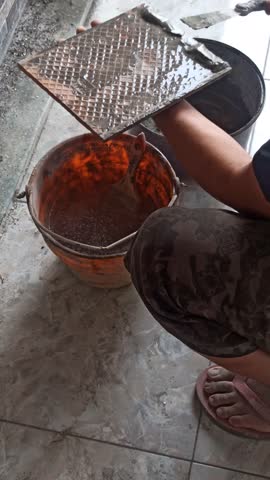 A construction worker installing ceramic tiles on a wall manually, showing craftsmanship, precision, and careful detail in home renovation.