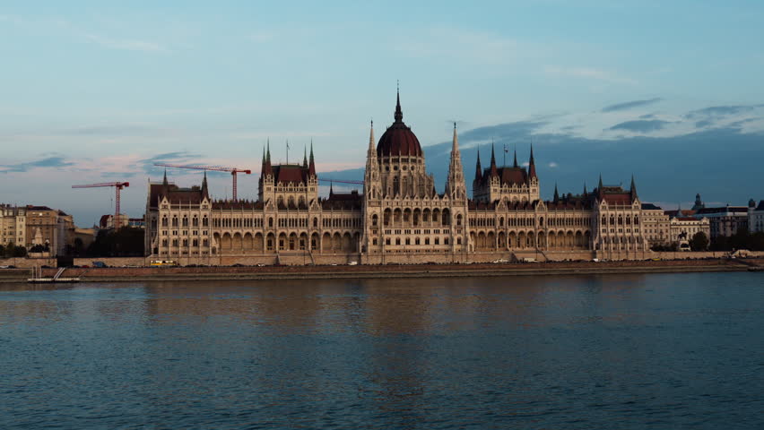 Evening view of Budapest Parliament with the Danube River in calm light, showcasing Hungary’s iconic architecture and serene city atmosphere.