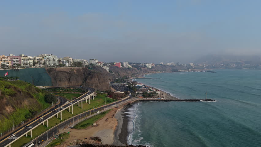 Aerial perspective of Pacific Ocean coast in Lima, Peru. High cliffs of the Miraflores district and the Circuito de Playas highway