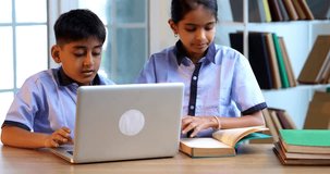 Indian School Kids Studying Together on Laptop in Classroom While Wearing School Uniforms, Group Learning, Sharing Knowledge, Collaborating on Academic Tasks Using Technology During Education Session - Powered by Shutterstock - Get 15% off with code: PIKWIZARD15