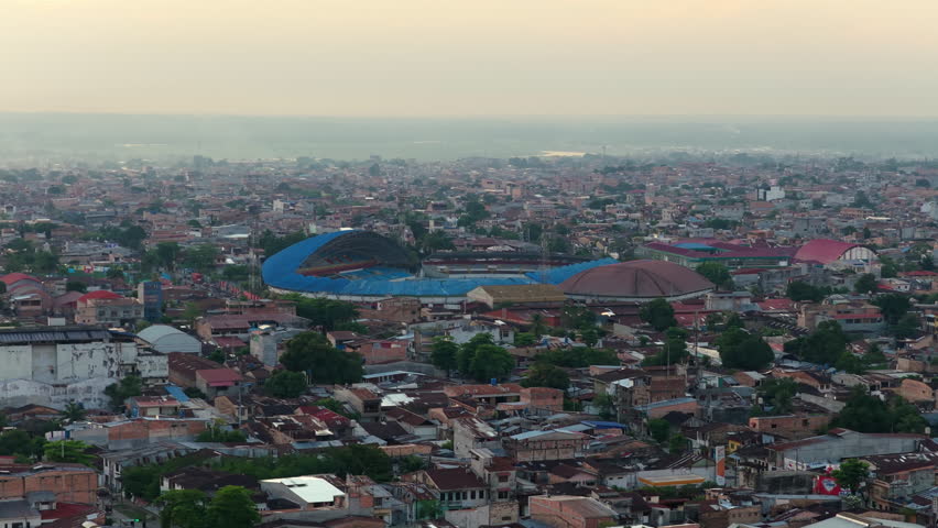 Aerial view of Iquitos, largest city in the Peruvian Amazon, showcasing urban landscape and the stadium at sunset