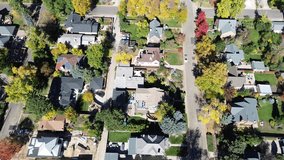 Home under roof construction wrapped in envelope cover in suburbs Denver, CO neighborhood surrounded by solar panel rooftops and mature trees in peak fall color. Quiet and clean street layout. USA - Powered by Shutterstock - Get 15% off with code: PIKWIZARD15