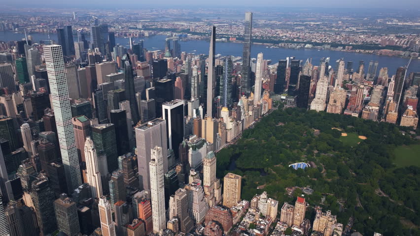Aerial view approaching supertall skyscrapers of Manhattan Midtown, in sunny NYC