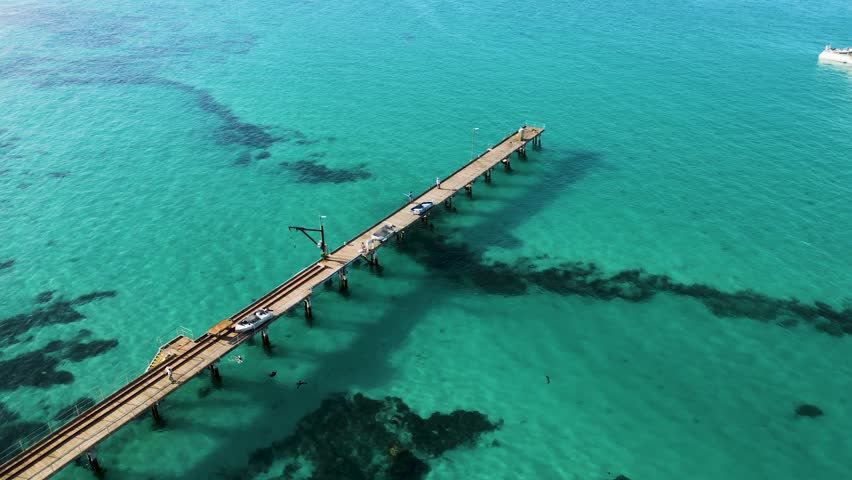 Drone view of Vivonne Bay jetty with people fishing and swimming, Kangaroo Island, South Australia