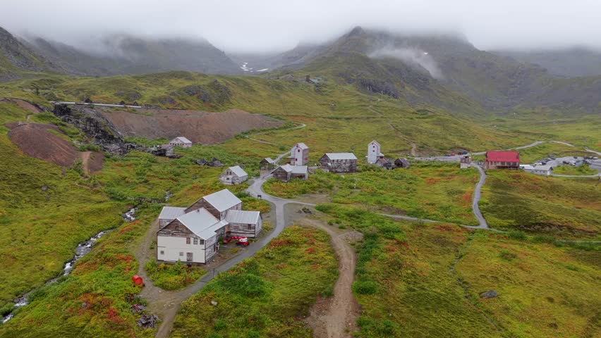 Aerial view of buildings along Gold Cord Road amid the green landscape and mountains, creating a serene yet striking contrast, Palmer, Alaska, United States.