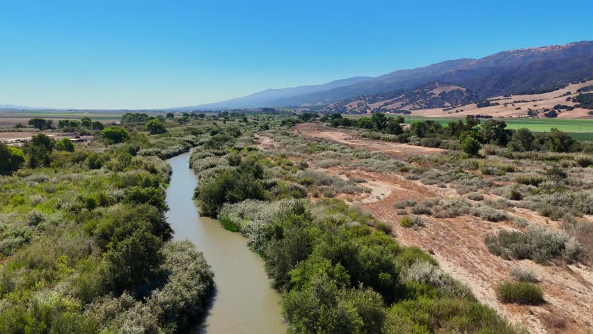 Aerial view of winding Salinas River with surrounding brush and distant hills near Chular California, USA