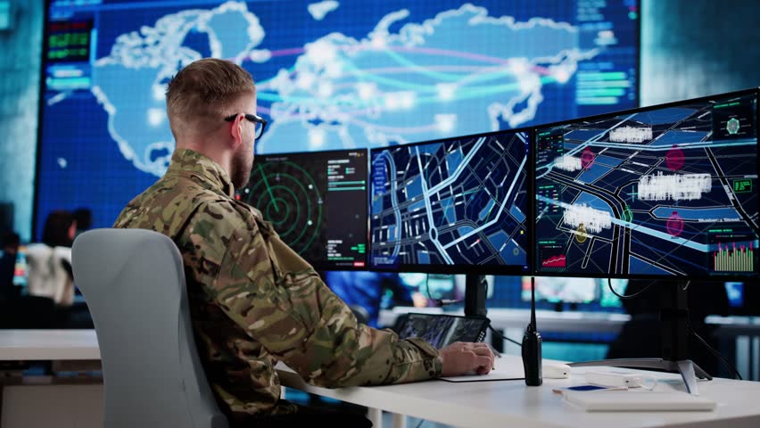 Government Army Control Center: Man Monitoring Soldiers At Computer Desk