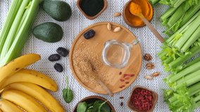 Female hand pouring a freshly blended green detox smoothie into a glass jar surrounded by healthy organic ingredients like celery, banana, avocado, spinach, and various superfoods - Powered by Shutterstock - Get 15% off with code: PIKWIZARD15