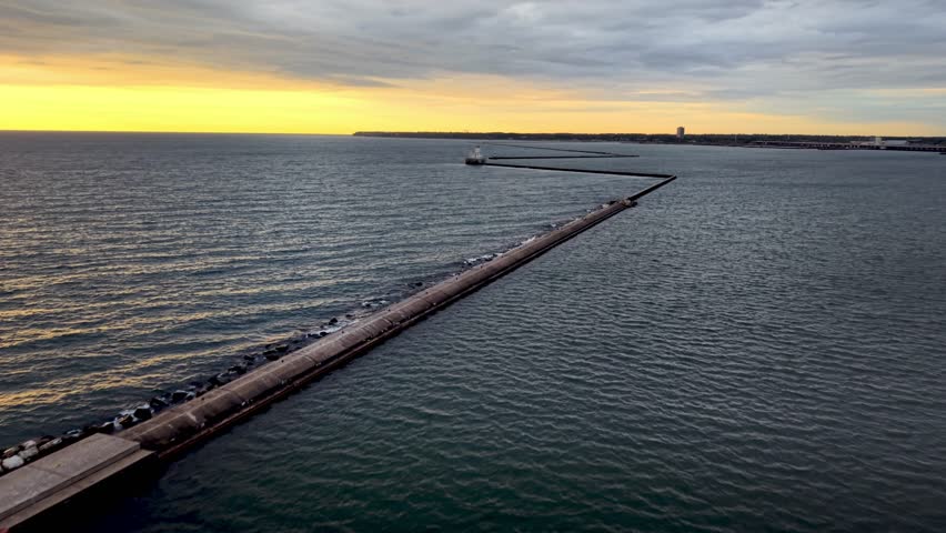 aerial push in to milwaukee breakwater light lighthouse at sunrise