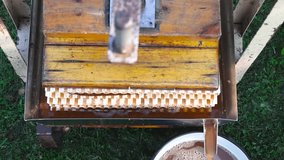 Top down view of a home garden diy apple press making golden brown and yellow apple juice and it is flowing into a bucket on green grass in slow motion. Smooth flow of juice.	 - Powered by Shutterstock - Get 15% off with code: PIKWIZARD15
