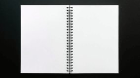 Open blank spiral notebook with white pages on a dark background ready for notes - Powered by Shutterstock - Get 15% off with code: PIKWIZARD15