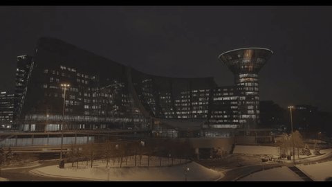 Drone Flying toward Futuristic Illuminated Business Building