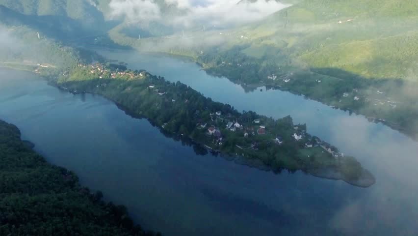 Serene lake landscape with mountains and mist creating a peaceful vista view
