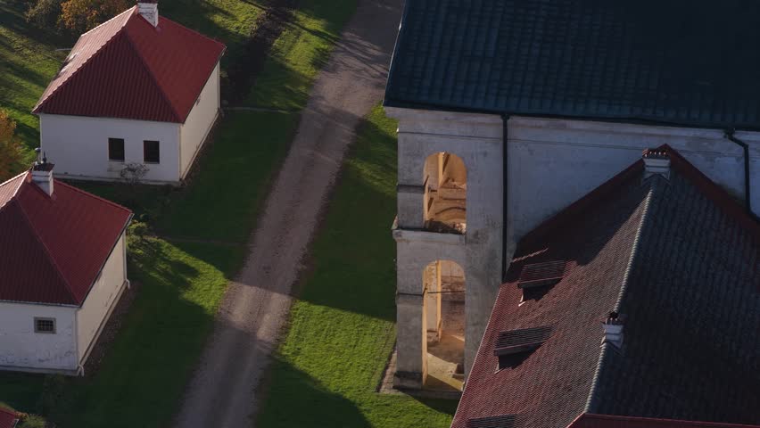 Detailed aerial view of Pažaislis Monastery’s Baroque facade, clock towers, and inner courtyard, highlighting historic architecture in warm morning light.