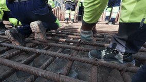 Construction workers are tying reinforcement bars with tying wire. Builders tying rebars. Real-time handheld footage - Powered by Shutterstock - Get 15% off with code: PIKWIZARD15