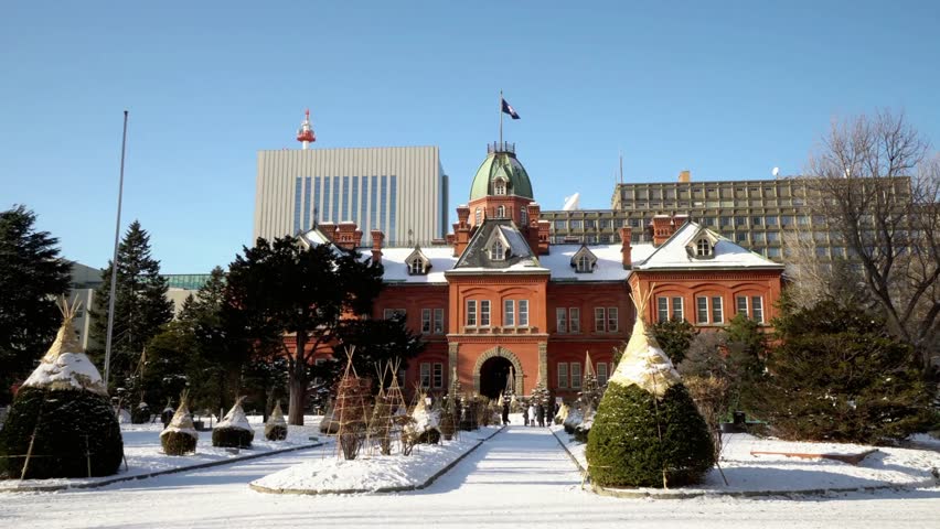 Historical red brick building in Sapporo covered in snow on a bright winter day