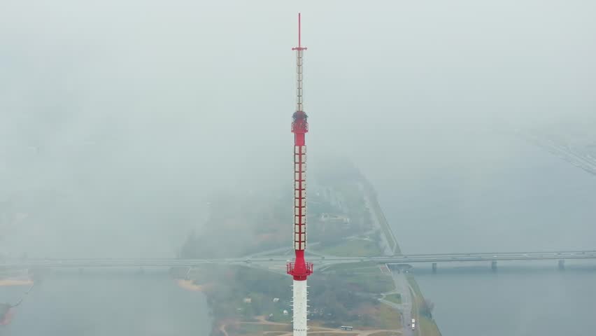 Aerial shot of Riga Television Tower surrounded by soft mist and bridges
