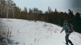 Wide angle shot of young woman hiking alone in winter walking on snow with backpack against beautiful forest scenery, copy space - Powered by Shutterstock - Get 15% off with code: PIKWIZARD15