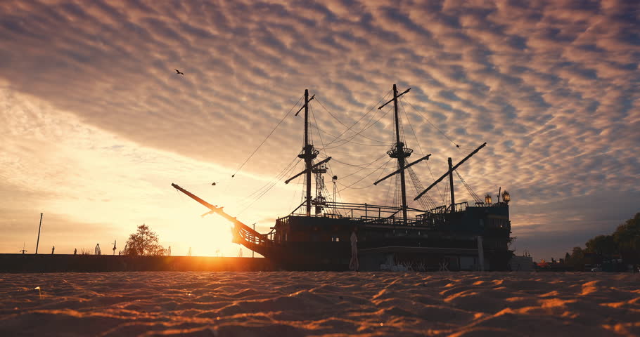 Sunset over the Beach With Old Vintage Ship Sailboat Docked On The Sea Shore of Varna city, Bulgaria