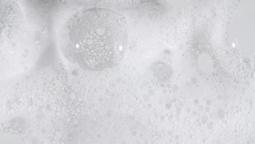 Texture of white soap foam with bubbles abstract background. Soap sud macro structure. Bathtup Soap Foam. Natural White Shampoo Bubbles Motion.