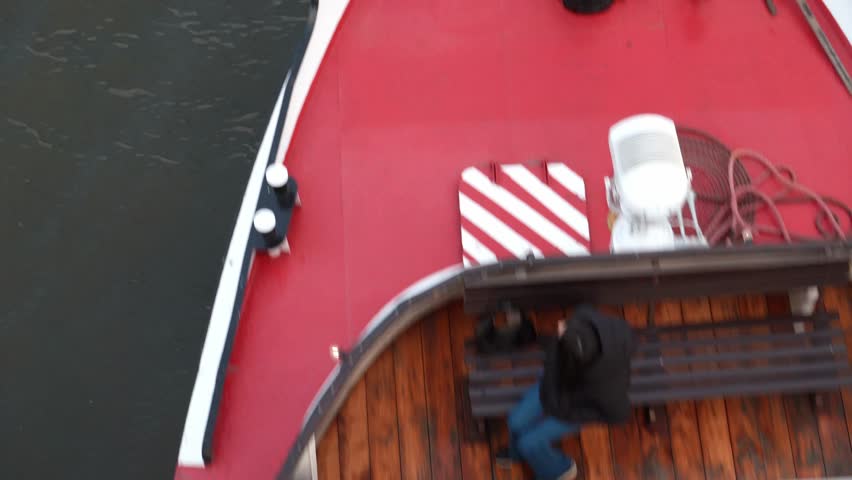People sailing on a riverboat viewed from above the bridge, sightseeing ship cruising on the river in sunny weather