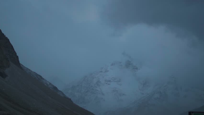 Dark stormy clouds above the snowy Himalayan mountain peaks during a winter storm at Shinkula Pass in Lahaul and Spiti district, Himachal Pradesh, India. Clouds cover the high altitude mountain.