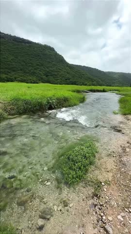 Clear River Flowing Through Green Valley