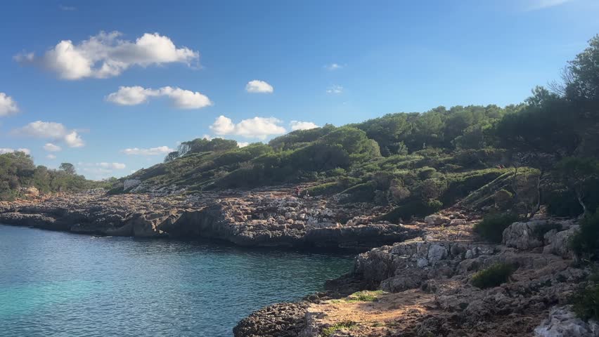rocky coastline and clear waters at cala sa nau on mallorca island spain under sunny sky