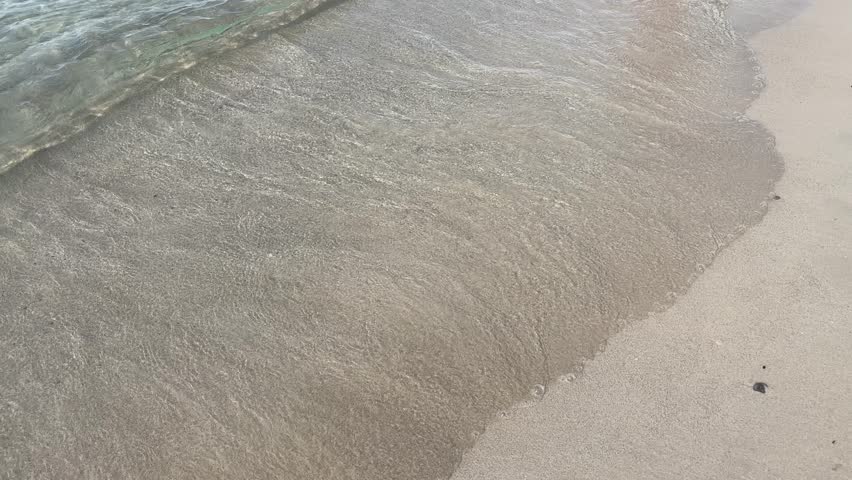 Close up of feet walking in transparent sea water at Cala Ses Covetes Mallorca