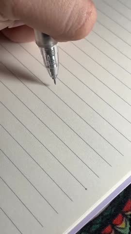 Close-up of Hand Writing Motivational Quote "Be Proud of Your Kind Heart" on Lined Paper