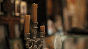 Burned candles in metal candle holder with blurred religious icons in background - Powered by Shutterstock - Get 15% off with code: PIKWIZARD15