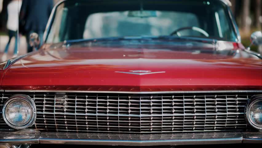 A classic burgundy Cadillac car parked on a sunny street in Cannes, France, showcasing elegant retro design, vintage style, and timeless automotive beauty.