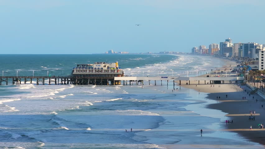 Oceanfront dining at the iconic Main Street Pier in Daytona Beach, Florida, with surrounding resorts and condos contributing to the vibrant coastal tourism scene.