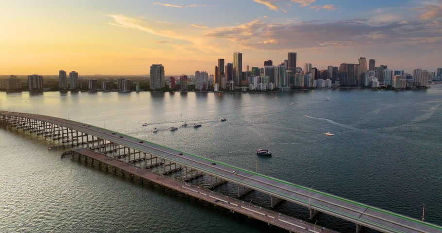 Traffic driving across William M Powell Bridge in downtown Miami Brickell, Florida. High-rise commercial and residential towers line the scenic waterfront.