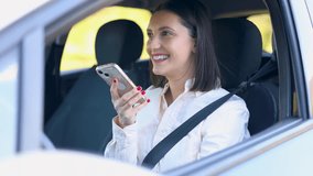Young businesswoman smiling while recording a voice message on her mobile phone. She is sitting in the driver's seat with her seatbelt on - Powered by Shutterstock - Get 15% off with code: PIKWIZARD15