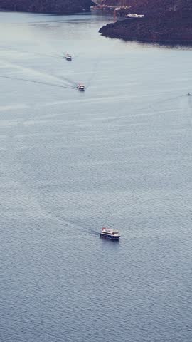 Fira in Santorini, Greece - October 9, 2025 - Boats transporting passengers from cruise ships toward the old harbor.